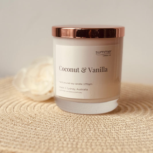 Hand-poured soy wax candle in a white jar with a rose gold lid, scented with Coconut & Vanilla. A creamy, tropical blend with notes of warm vanilla and sweet coconut. Clean-burning and perfect for gifting or creating a relaxed, beachy vibe.