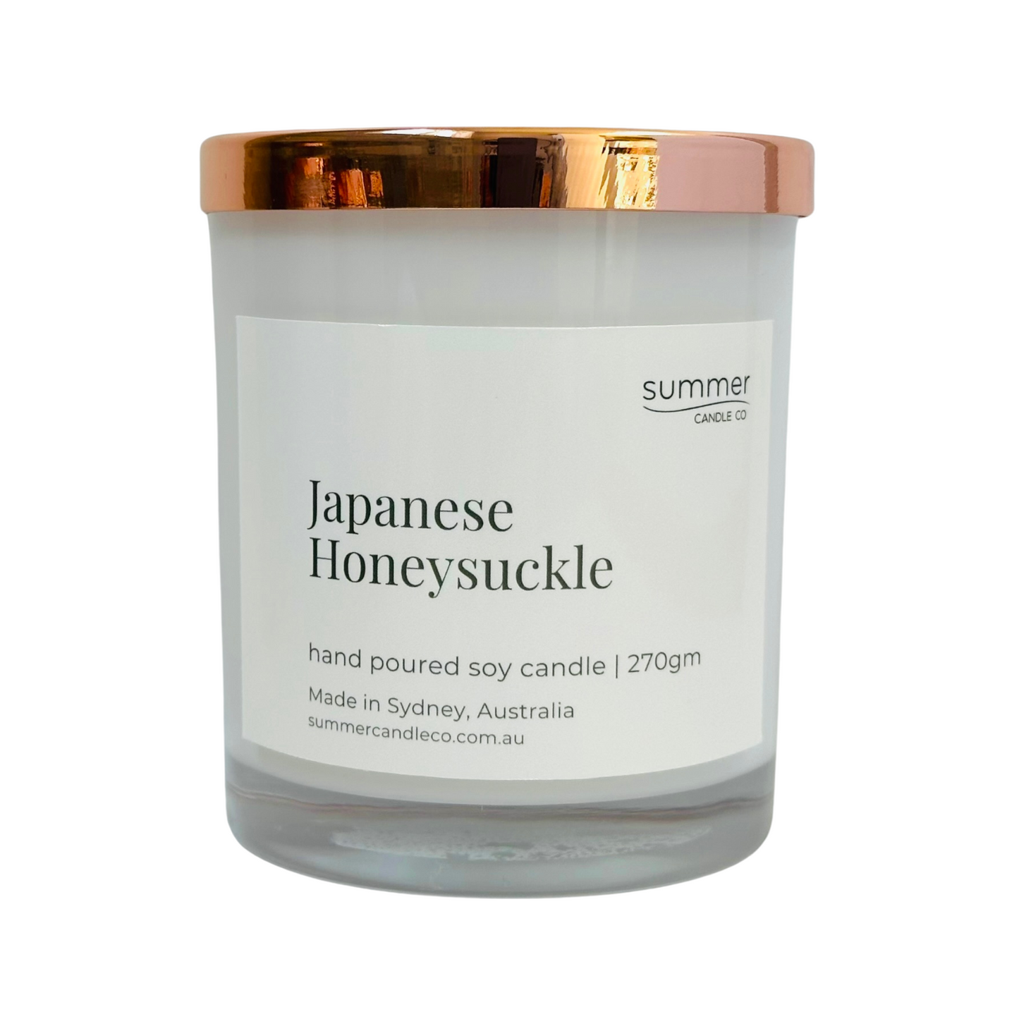 Hand-poured soy wax candle in a white jar with a rose gold lid, scented with Japanese Honeysuckle. A sweet floral aroma with notes of jasmine and honey. Clean-burning and perfect for gifting or creating a calming, elegant atmosphere.