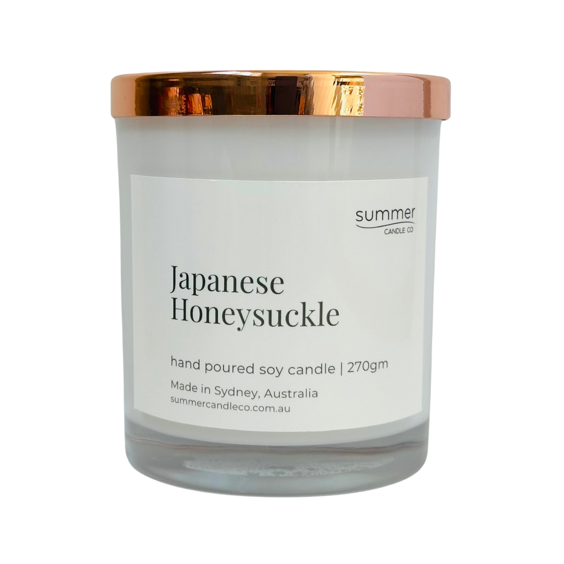 Hand-poured soy wax candle in a white jar with a rose gold lid, scented with Japanese Honeysuckle. A sweet floral aroma with notes of jasmine and honey. Clean-burning and perfect for gifting or creating a calming, elegant atmosphere.