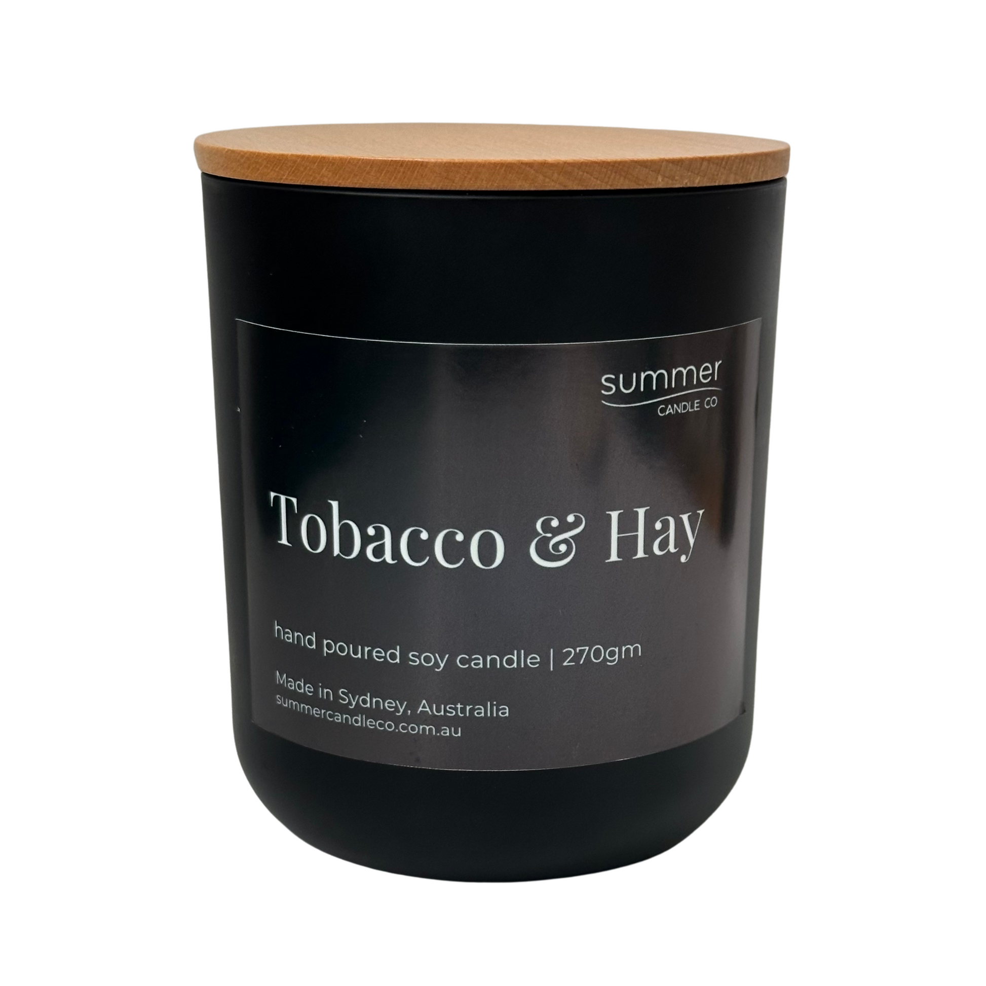 Hand-poured soy wax candle in a sleek black jar with a natural wooden lid, scented with Tobacco & Hay. Features earthy notes of dried hay, tobacco leaf, and musk. A clean-burning, masculine fragrance ideal for creating a warm, rustic atmosphere.