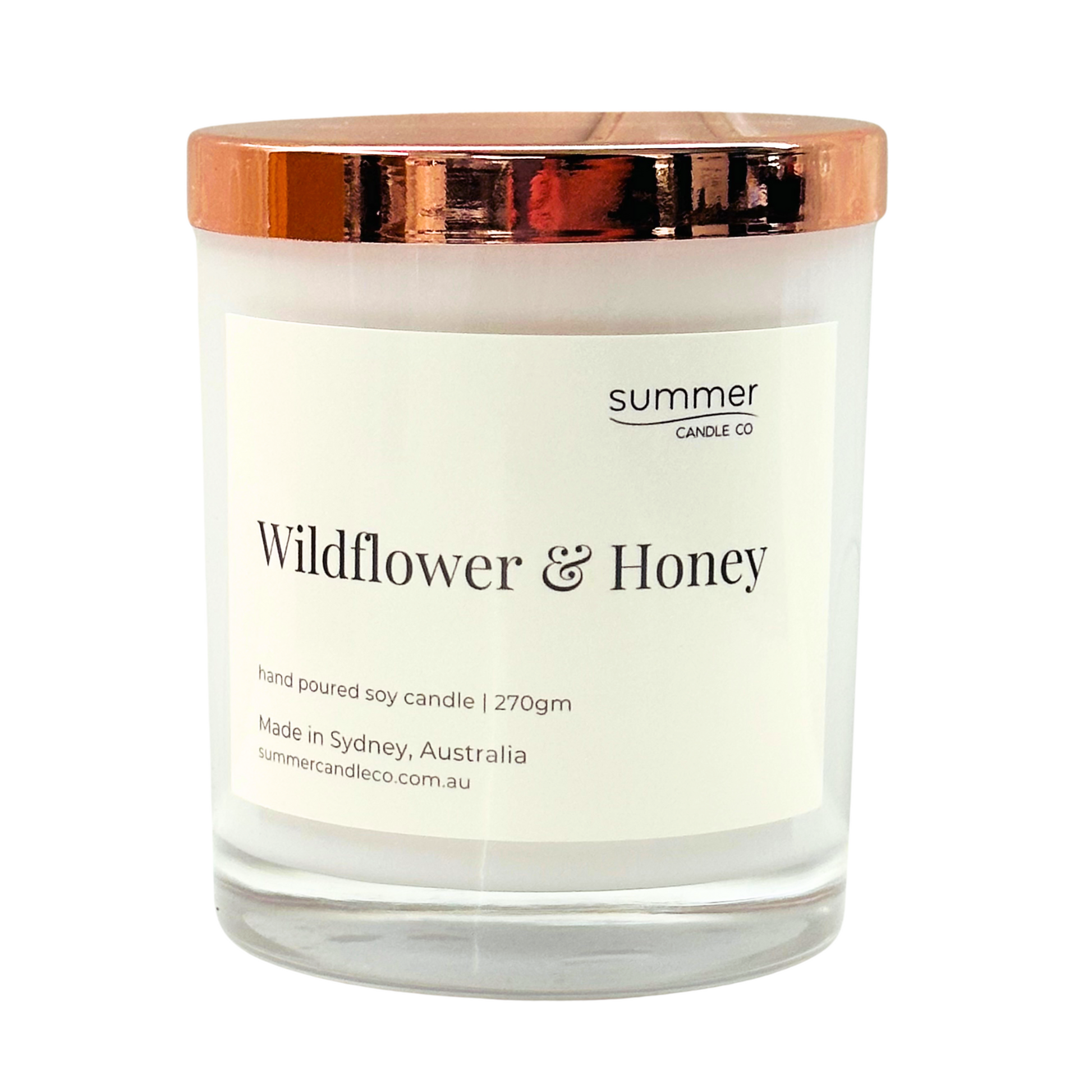 Hand-poured soy wax candle in a white jar with a rose gold lid, scented with Wildflower & Honey. A sweet, floral blend with notes of blooming wildflowers and golden honey. Clean-burning and perfect for gifting or creating a cozy, nature-inspired feel.