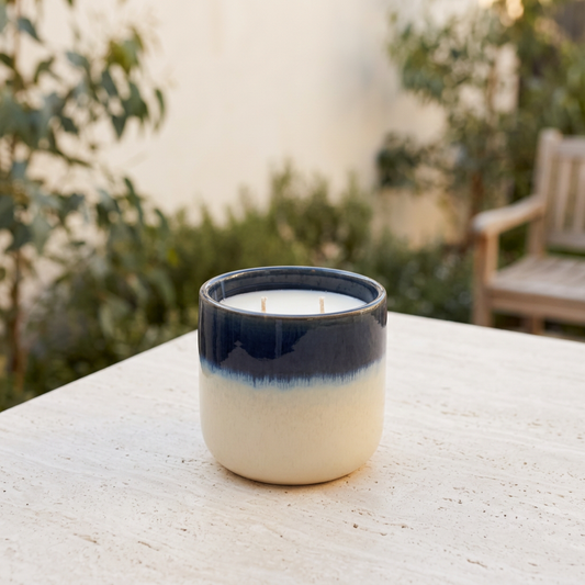 Blue and cream citronella candle in a coastal courtyard