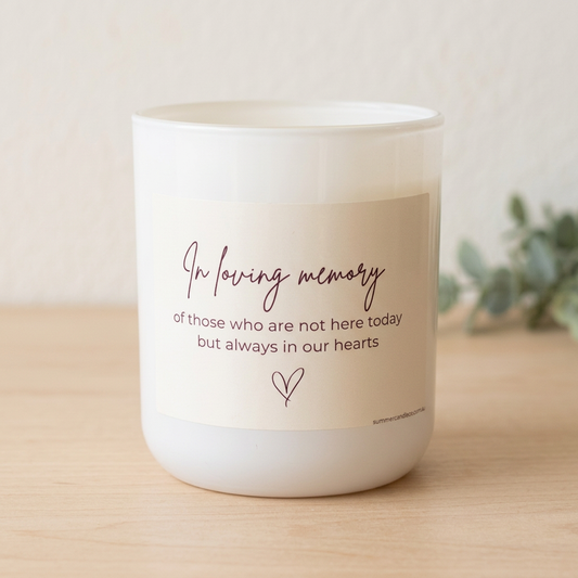 In Loving Memory candle on pale timber with soft greenery and no fabric